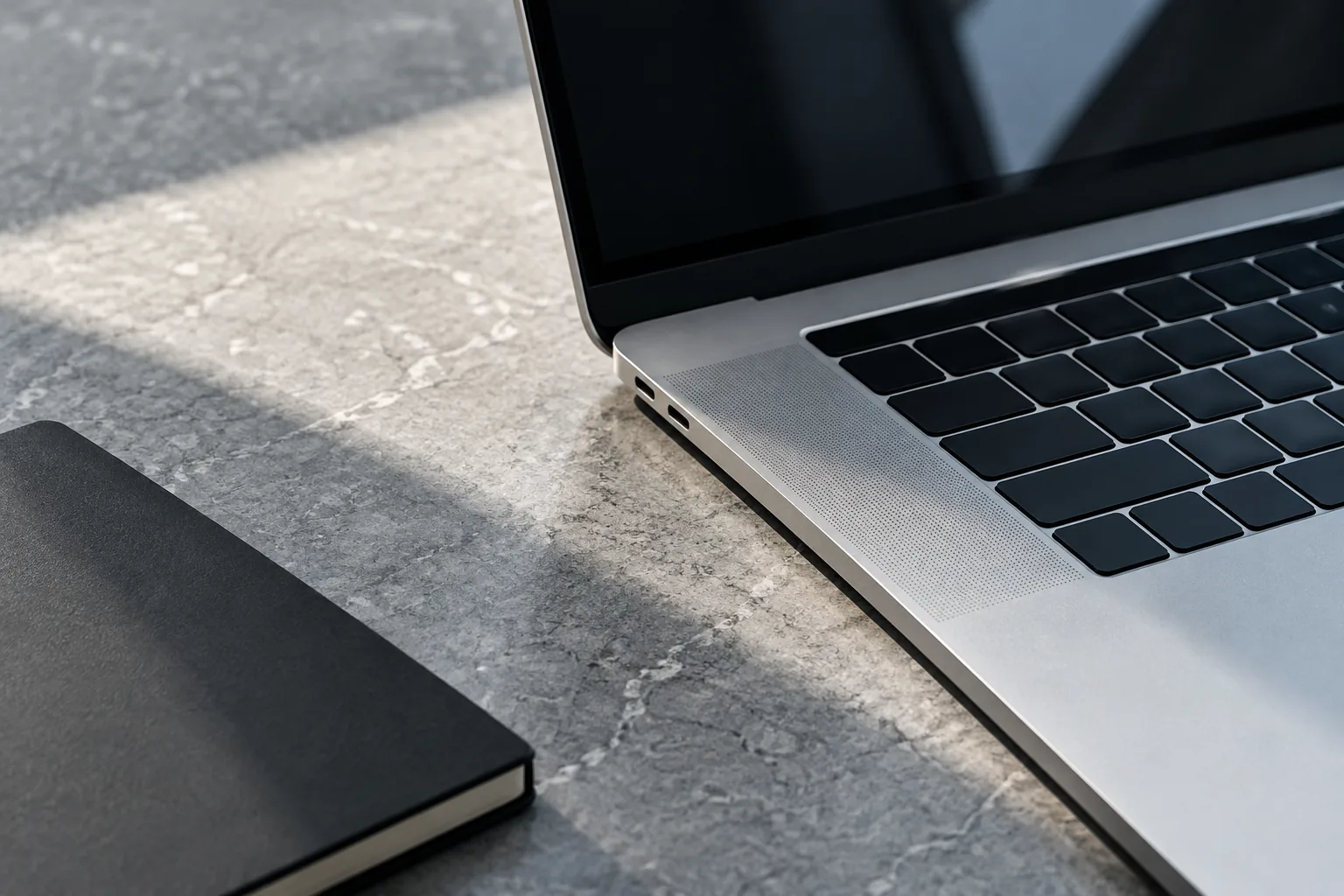 A MacBook open on a desk in natural light